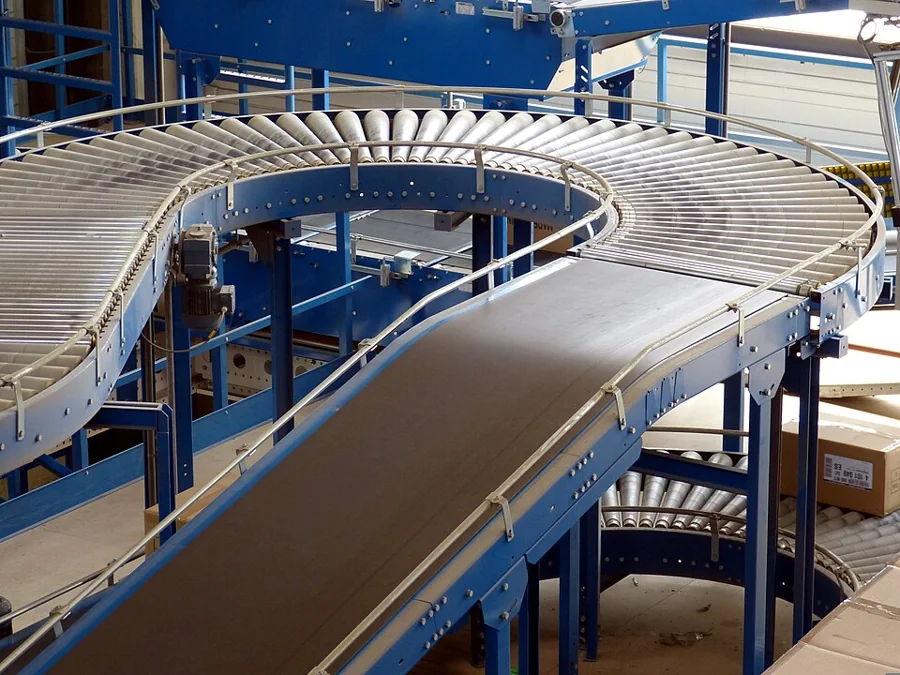 A blue powered conveyor line in a modern plant